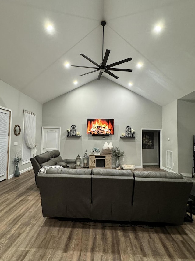 living room with dark wood-type flooring, ceiling fan, and high vaulted ceiling