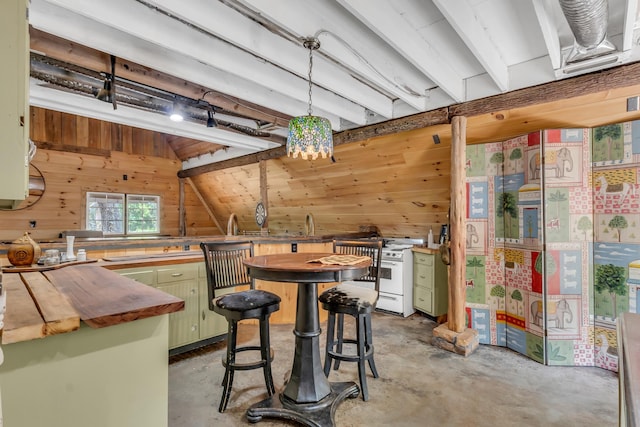 kitchen featuring gas range gas stove, wooden walls, green cabinetry, concrete floors, and butcher block countertops