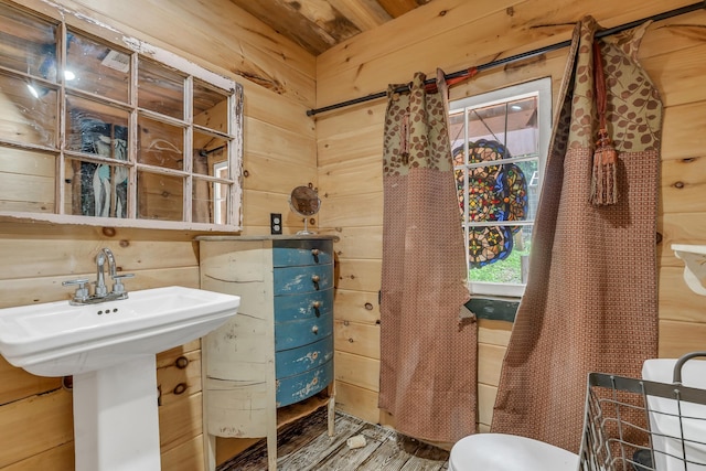 bathroom with wooden walls and sink