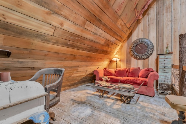 sitting room featuring wood walls, hardwood / wood-style floors, wooden ceiling, and lofted ceiling