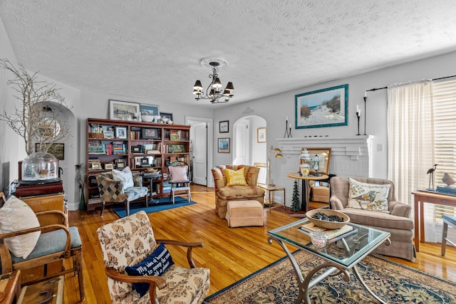 3004 Vine St, White Pine, TN 37890 - living room featuring wood finished floors, a chandelier, arched walkways, and a textured ceiling