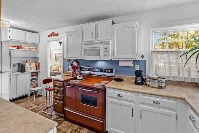 3004 Vine St, White Pine, TN 37890 - kitchen featuring white appliances, white cabinetry, a textured ceiling, and light countertops