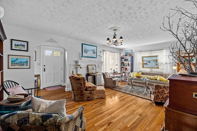 3004 Vine St, White Pine, TN 37890 - living area with arched walkways, a chandelier, light wood-type flooring, and a textured ceiling