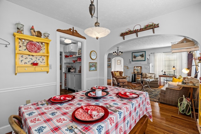 3004 Vine St, White Pine, TN 37890 - dining space featuring arched walkways, a textured ceiling, and wood finished floors