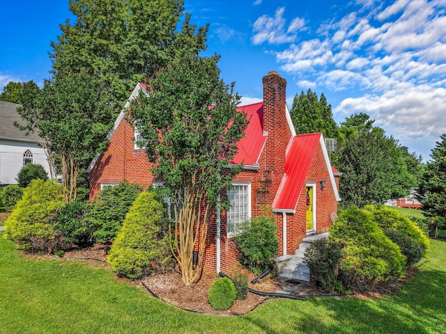 3004 Vine St, White Pine, TN 37890 - view of home's exterior featuring brick siding, a metal roof, a yard, and a chimney