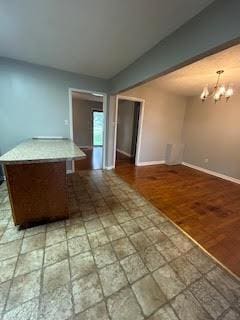 interior space with baseboards, tile patterned floors, and an inviting chandelier