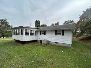 back of house featuring a sunroom and a lawn