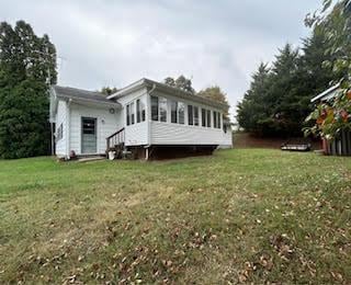 rear view of house with entry steps and a lawn