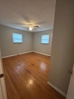 unfurnished bedroom featuring ceiling fan, baseboards, and wood finished floors