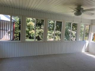 unfurnished sunroom featuring a wealth of natural light and a ceiling fan