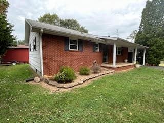 exterior space with a yard and brick siding