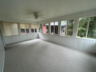 unfurnished sunroom with ceiling fan