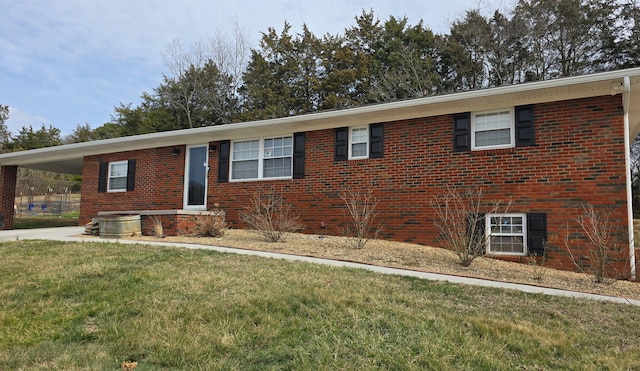 ranch-style home featuring a front lawn, a carport, and brick siding