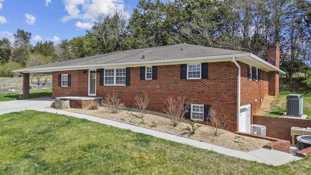 ranch-style house featuring brick siding, a garage, a chimney, cooling unit, and driveway