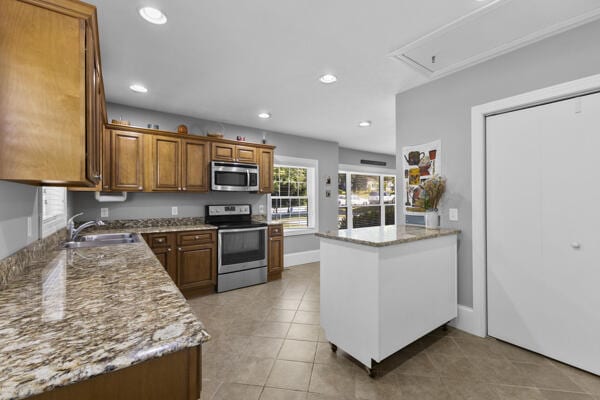 1211 W 6th N St, Morristown, TN 37814 - kitchen featuring stainless steel appliances, brown cabinetry, recessed lighting, light stone counters, and light tile patterned floors