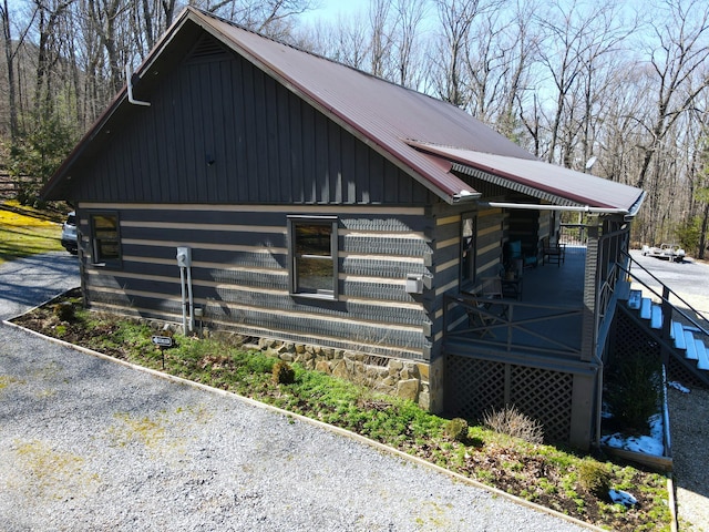 view of home's exterior featuring metal roof and stairs