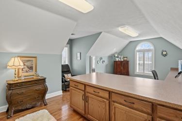 office space with light wood-type flooring, baseboards, and lofted ceiling