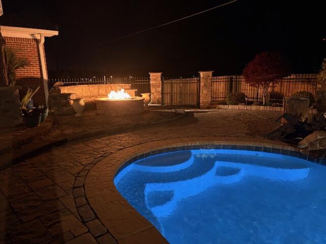 2657 Lakemoore Dr, Morristown, TN 37814 - pool at twilight featuring a fire pit, a patio, and fence