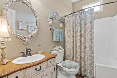 full bathroom with toilet, shower / bathtub combination with curtain, and vanity