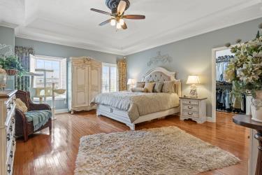 bedroom with baseboards, a tray ceiling, and wood finished floors