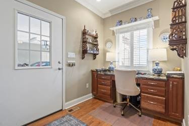 office space featuring ornamental molding, wood finished floors, visible vents, and baseboards