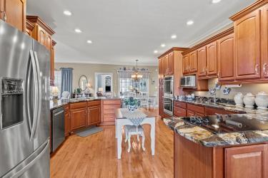 kitchen with stainless steel appliances, light wood-type flooring, brown cabinets, and a peninsula