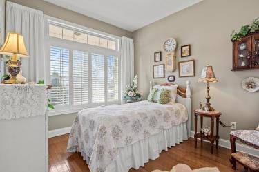 bedroom featuring wood finished floors and baseboards