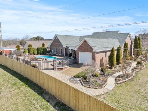 view of swimming pool featuring a lawn, fence, and a fenced in pool