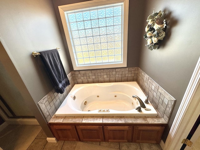 bathroom with tile patterned flooring, a bathing tub, and a healthy amount of sunlight