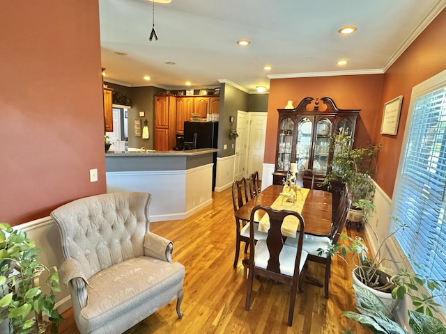 dining area featuring light hardwood / wood-style flooring and ornamental molding