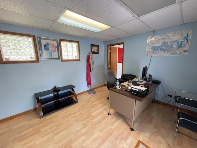 office space featuring a paneled ceiling and light wood-type flooring