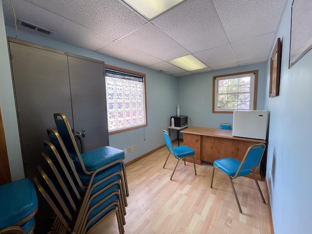 office featuring a drop ceiling, plenty of natural light, and light wood-type flooring