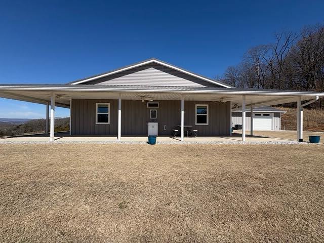 view of front of home featuring a carport, board and batten siding, and a front yard