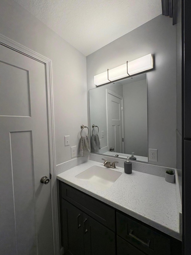 bathroom featuring a textured ceiling and vanity