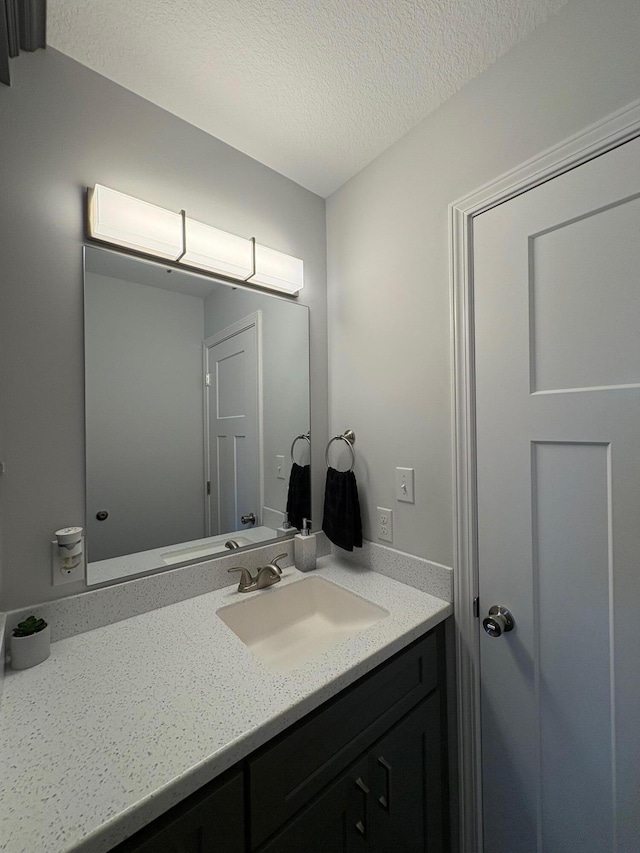 bathroom with a textured ceiling and vanity