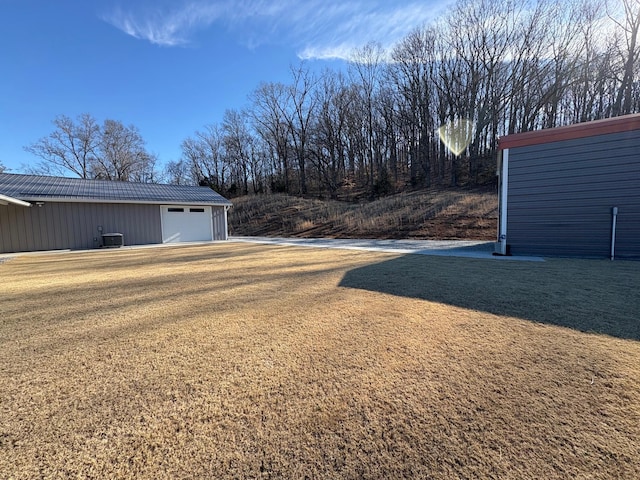 view of yard featuring central AC and an outdoor structure