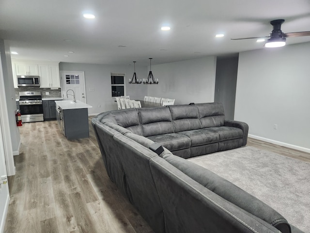 living room featuring recessed lighting, wood finished floors, a ceiling fan, and baseboards