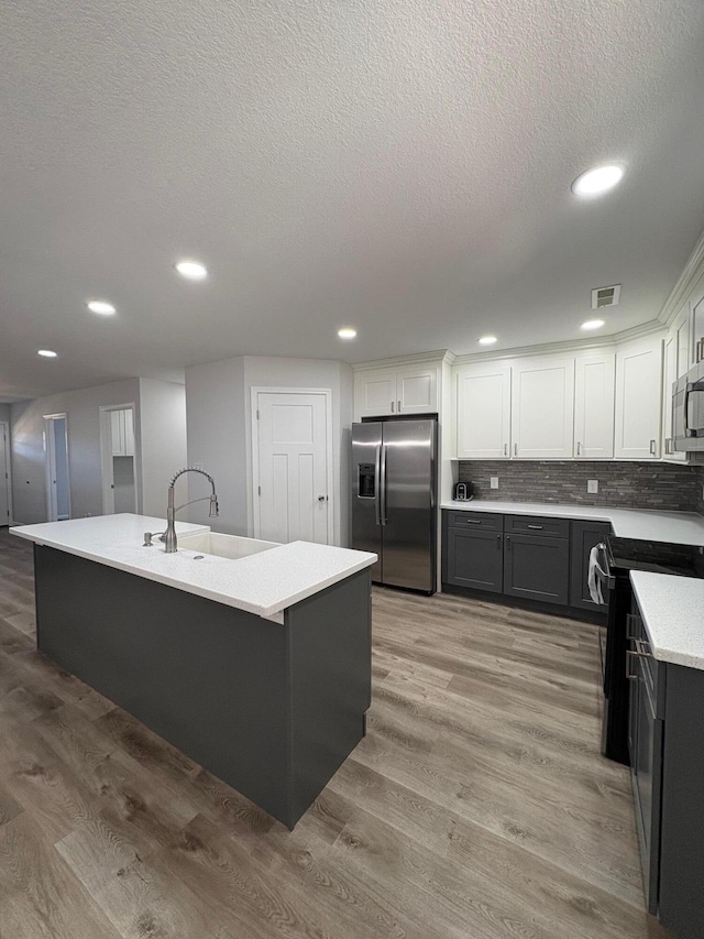 kitchen featuring stainless steel appliances, a center island, and a sink