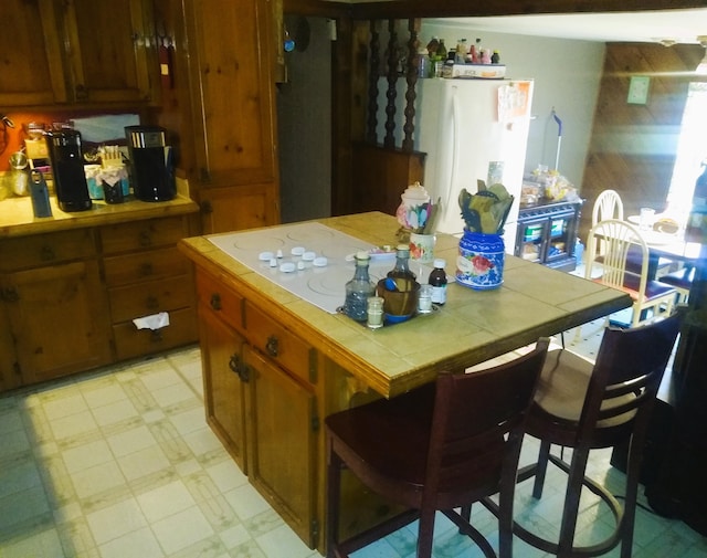 kitchen with white refrigerator and tile countertops