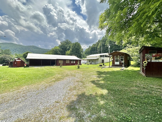 4140 Chavis Rd, Cosby, TN 37722 - view of grassy yard featuring driveway, a carport, a mountain view, and a storage shed