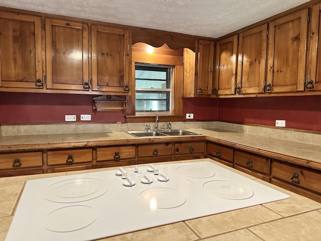 4140 Chavis Rd, Cosby, TN 37722 - kitchen featuring brown cabinetry, white cooktop, a textured ceiling, and tile counters