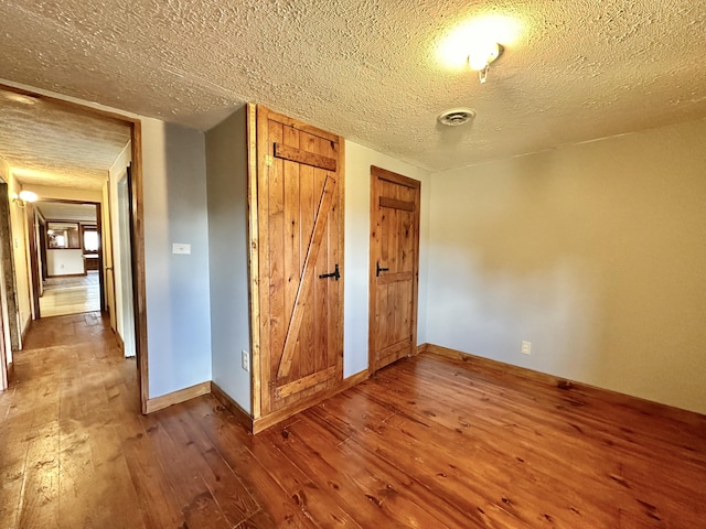4140 Chavis Rd, Cosby, TN 37722 - unfurnished bedroom with hardwood / wood-style flooring, a textured ceiling, and two closets