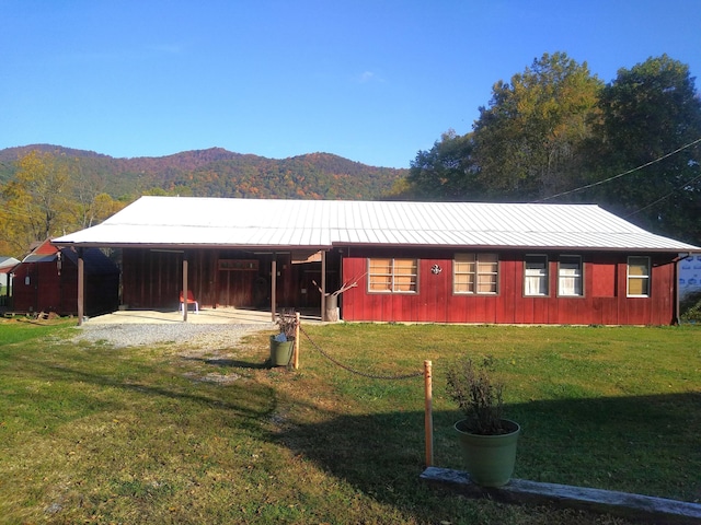 view of front of house with a mountain view and a front yard