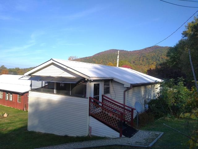 view of front of home with a mountain view and a front lawn