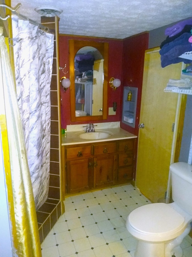 bathroom with vanity, a textured ceiling, and toilet