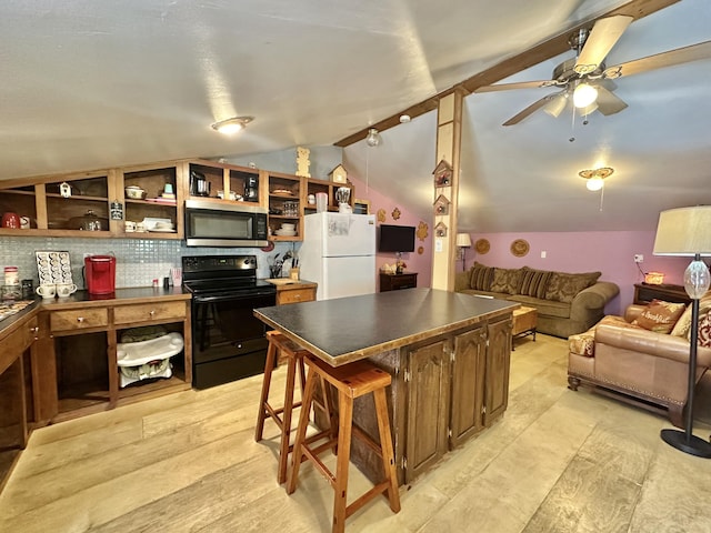 4140 Chavis Rd, Cosby, TN 37722 - kitchen with black range with electric stovetop, stainless steel microwave, freestanding refrigerator, dark countertops, and vaulted ceiling