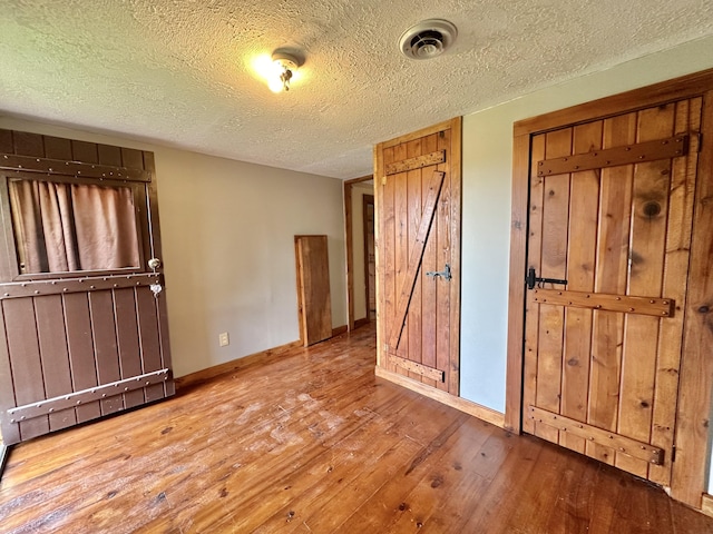 4140 Chavis Rd, Cosby, TN 37722 - unfurnished bedroom featuring hardwood / wood-style floors and a textured ceiling