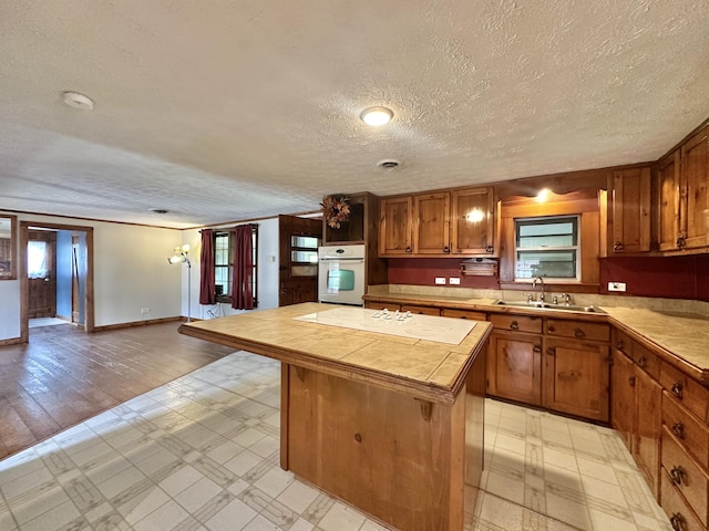 4140 Chavis Rd, Cosby, TN 37722 - kitchen with white appliances, light flooring, a kitchen island, a textured ceiling, and tile counters
