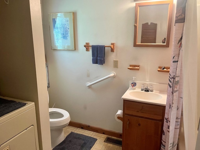 bathroom with vanity, washer / clothes dryer, and toilet