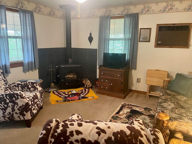 living room with light colored carpet, a wood stove, and a wealth of natural light